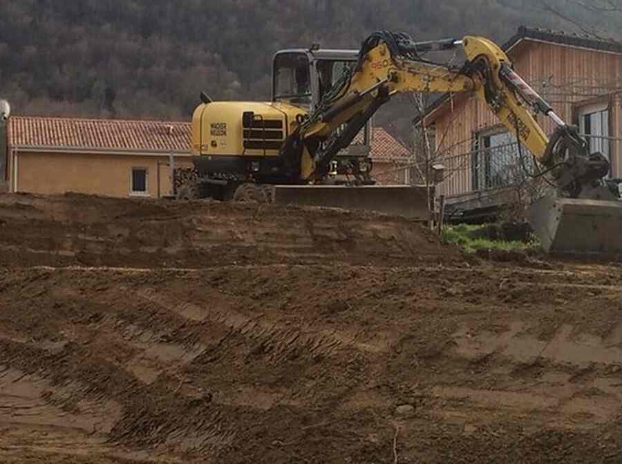 Pelle mécanique en travaux de terrassement devant une maison, chantier de La Tour Terrassement
